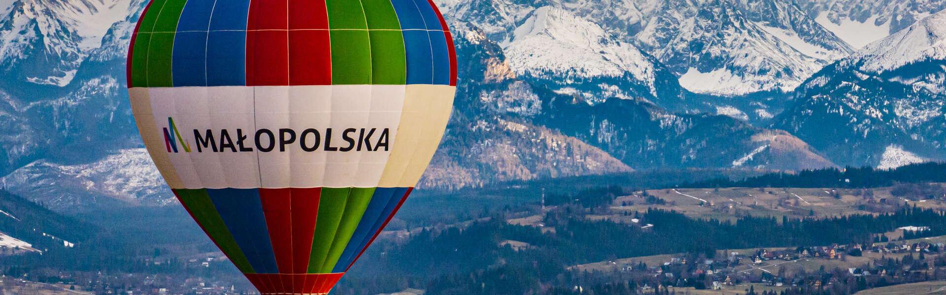 Balon Małopolska nad Małopolską. W tle ośnieżone tatrzańskie szczyty